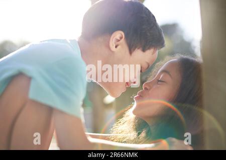 Nahaufnahme Schwester küsst süßen Bruder mit Down-Syndrom in der Sonne Stockfoto