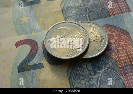 2 Euro-Münzen auf 20 Euro-Banknoten. Münzumkehr. Euro-Münzen und -Banknoten. Stockfoto