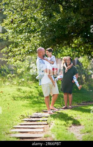 Fröhliche Familienspaziergänge auf dem Wanderweg im sonnigen Sommerpark Stockfoto