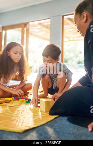 Familie spielt mit Spielzeug auf der Matte zu Hause Stockfoto