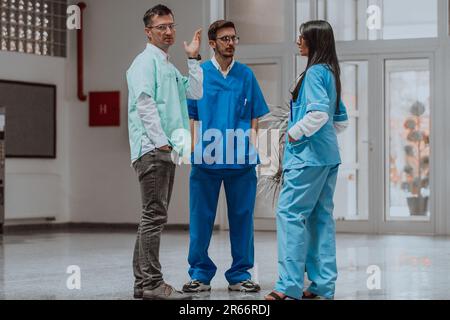 Krankenschwester, Medizintechniker und Arzt diskutieren in einem modernen High-Tech-Krankenhaus über verschiedene medizinische Themen und präsentieren Teamarbeit Stockfoto