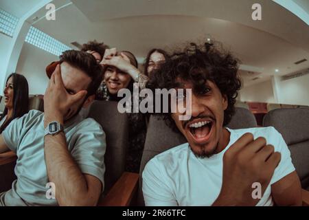 Omedy Film, mit Lächeln in einem Kino eine vielfältige Gruppe von Teenagern versammelt sich, beobachtet ihre Gesichter, genießt das gemeinsame Lachen und die Freude von Stockfoto