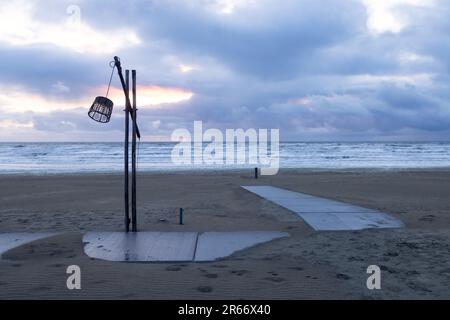 Eine einsame Laterne auf einem Holzpfahl an einem verlassenen Sandstrand der Nordsee Stockfoto