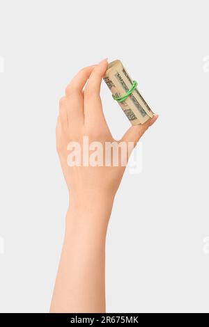 Weibliche Handrolle mit hundert-Dollar-Banknoten, gebunden mit Gummiband auf weißem Hintergrund Stockfoto