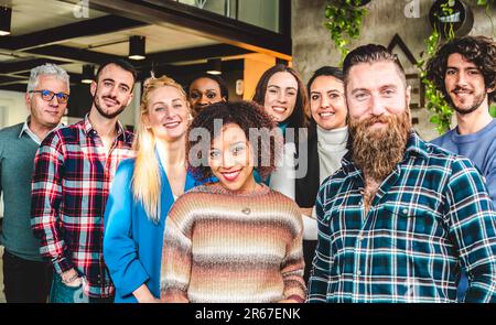 Generationenübergreifende und multiethnische Arbeiter, die vor der Kamera lächeln, in einem Büro, in dem sich die Wirtschaft verändert – multikulturell, arbeitende Angestellte, Unternehmer und Te Stockfoto