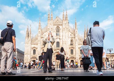 Italien, Mailand Piazza Duomo Kathedrale, viele Touristen machen Fotos. Viele Leute machen Fotos auf dem Domplatz. Asiatische Touristen in Mailand. Stockfoto