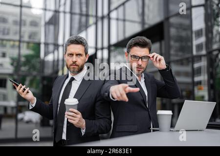 Ausdrucksgesicht eines emotionalen Geschäftsmannes. Ein seriöser Geschäftsmann, der mit dem Finger auf Sie zeigt. Porträt eines Geschäftsmannes im Anzug im Freien. Zusammenarbeit mit der Stockfoto