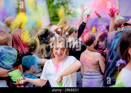 Hübsches Mädchen im traditionellen indischen Holi Festival mit bunter Puder, das Spaß hat. Weibliche Teenagerin genießt positiven Urlaub in Indien Stockfoto