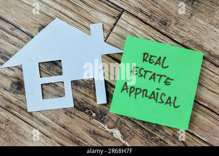 Konzept der Immobilienbewertung Schreiben auf Haftnotizen isoliert auf einem Holztisch. Stockfoto