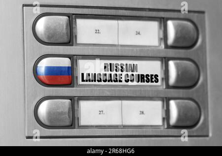Auf der Gegensprechanlage befindet sich ein Knopf mit der russischen Flagge und der Aufschrift: Russische Sprachkurse. Stockfoto