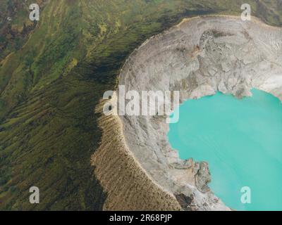 Der türkisfarbene Schwefelwassersee am Kawah Ijen Vulkan in Ost-Java, Indonesien, ist von Klippen umgeben. Stockfoto