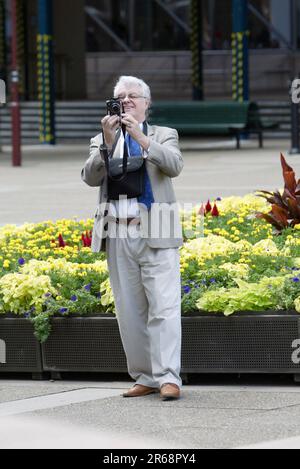 Ein Fotograf, der eine moderne Digitalkamera in der Macquarie Street am Queens Square in der Nähe des Hyde Park in Sydney verwendet. Stockfoto