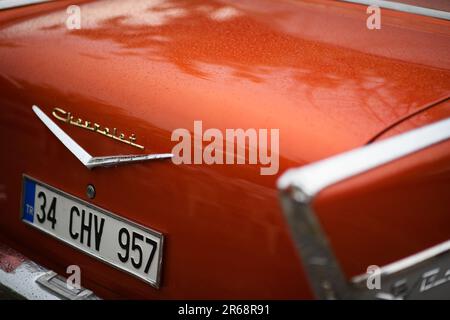 Izmir, Türkei - 3. Juni 2023: Nahaufnahme des regengeschmierten Chevrolet-Logos auf dem Kofferraum eines orangefarbenen 1957 Chevrolet beim IZKOD Classic Car Meeting in BU Stockfoto