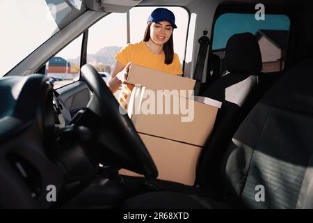 Der Kurier nimmt das Paket vom Auto ab. Lieferservice Stockfoto