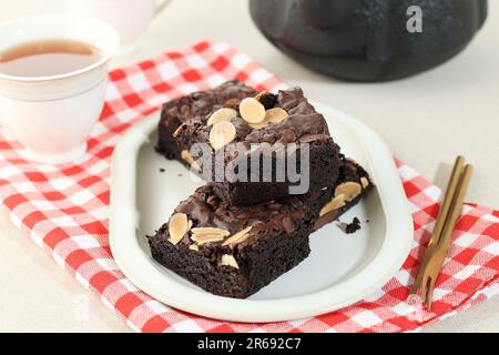 Brownie Butter Cake mit Mandelscheiben und Schokoladenchips, serviert zum Tee Stockfoto