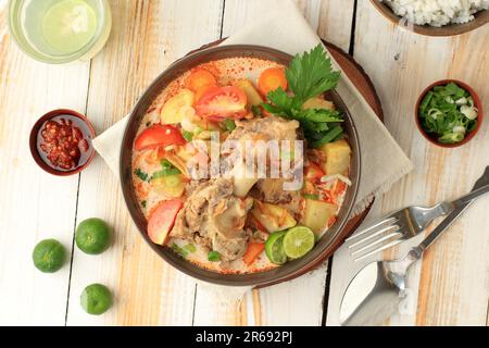 Soto Tangkar ist eine traditionelle Betawi-Suppe aus gehackten Ziegen- oder Rinderrippchen, gekocht in dünner Kokosmilch, gewürzt mit rotem Curry. Indonesische Küche Stockfoto