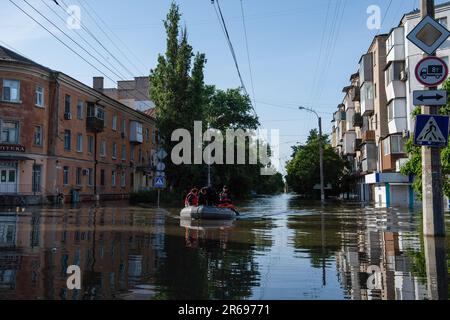 Kherson, Ukraine. 07. Juni 2023. Rettungskräfte in einem Boot machen sich einen Tag nach dem Platzen des Kakhovka-Staudamms entlang des Dnipro-Flusses durch die Flutgewässer in der Innenstadt von Kherson, Ukraine, auf den Weg durch die Flutwasserquellen an beiden Ufern des Flusses südlich des Staudamms. In Dörfern entlang des Dnipro kam es infolge der Zerstörung des Kakhovka-Staudamms zu massiven Überschwemmungen, die die Gemeinden entlang des Flusses im Süden belasten und die Wasserstände für die Gemeinden im Norden gefährlich niedrig fielen. Kredit: SOPA Images Limited/Alamy Live News Stockfoto