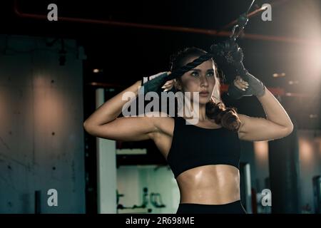 Sportliche Frau trainiert auf Multistation im Fitnessstudio für Arm- und Schultermuskulatur. Fitness-Training im Fitnessstudio. Stockfoto