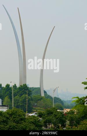 Washington, D.C., USA - 7. Juni 2023: Die Washington National Cathedral ist durch den Rauch der kanadischen Waldbrände kaum zu sehen (unten rechts), während das United States Air Force Memorial im Vordergrund steht. Aufgrund der gefährlichen Luftverhältnisse wurden für den Großraum Washington Warnmeldungen zur Luftqualität ausgegeben. (Bild: ©John M. Chase / Alamy Live News) Stockfoto