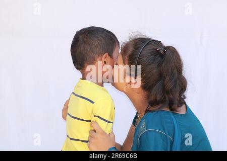 Indianermädchen küsst einen kleinen Jungen auf die Wange Stockfoto