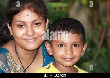 Das indische Mädchen hält einen kleinen Jungen fest Stockfoto