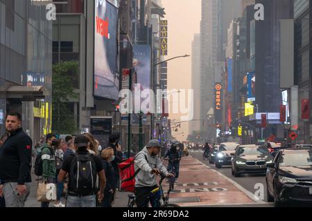 New York, Usa. 07. Juni 2023. NEW YORK, NEW YORK - 07. JUNI: Die Menschen machen sich auf den Weg um den Times Square inmitten von Rauch von kanadischen Waldbränden, die die Skyline von New York City am 7. Juni 2023 in New York City überdecken. New York stand Dienstagabend an der Spitze der Liste der am meisten verschmutzten Großstädte der Welt, da die Ostküste weiterhin mit Rauch von den Bränden bedeckt ist. Die Stadt gab eine Luftqualitätsempfehlung heraus, in der alle Bürger dringend aufgefordert wurden, sich im Haus zu halten. Kredit: Ron Adar/Alamy Live News Stockfoto