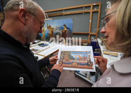 06. Juni 2023, Sachsen, Leipzig: Die Restauratoren Rüdiger Beck und Angelica Hoffmeister-zur Nedden arbeiten öffentlich am Max-Klinger-Gemälde „das Urteil von Paris“ im Museum der Schönen Künste Leipzig, während das Museum geöffnet ist. Die Komposition mit einer Gesamthöhe von 3,70 Metern und einer Länge von etwa 7,50 Metern war einfach zu groß für die Werkstatt und wird daher vor Ort restauriert. Besucher können beobachten, wie Risse in der Leinwand repariert werden, Farben wieder leuchten und Rahmen erneuert werden. Nach dem Sommer wird die Arbeit, die aus mehreren Leinwänden, Holz- und Putzelementen besteht, verschwinden Stockfoto