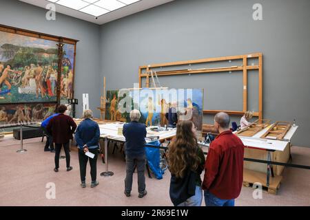 06. Juni 2023, Sachsen, Leipzig: Restauratoren Rüdiger Beck (m) und Angelica Hoffmeister-zur Nedden (r) arbeiten öffentlich am Max Klinger Gemälde „das Urteil von Paris“ im Museum der Schönen Künste Leipzig, während das Museum geöffnet ist. Die Komposition mit einer Gesamthöhe von 3,70 Metern und einer Länge von etwa 7,50 Metern war einfach zu groß für die Werkstatt und wird daher vor Ort restauriert. Besucher können beobachten, wie Risse in der Leinwand repariert werden, Farben wieder leuchten und Rahmen erneuert werden. Nach dem Sommer wird die Arbeit, die aus mehreren Leinwänden, Holz- und Gipselementen besteht, wi Stockfoto