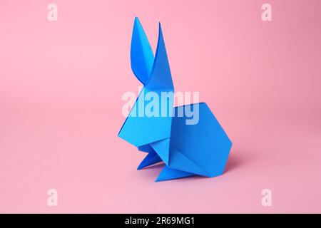 Origami-Kunst. Papierkaninchen auf pinkfarbenem Hintergrund Stockfoto