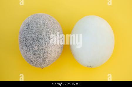 Verschiedene leckere reife Melonen auf gelbem Hintergrund, flach liegend Stockfoto