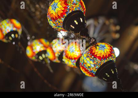 Türkischer Markt mit vielen traditionellen, bunten, handgefertigten türkischen Lampen und Laternen. Beliebte Souvenirs aus der Türkei, selektiver Fokus auf Laternen, verschwommenes B Stockfoto