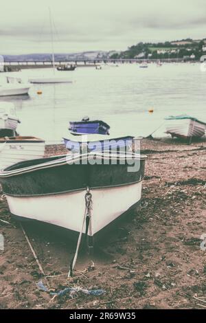 Ruderboote strandeten bei Ebbe am Teignmouth 'Back Beach' in Devon. Stockfoto