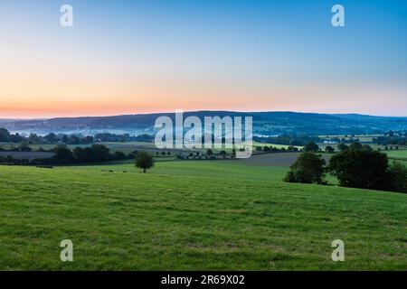 Ein früher Morgen mit einem Himmel voller wunderschöner Farben während des Sonnenaufgangs in der sanften Hügellandschaft von Limburg mit spektakulärem Blick über die typischen Stockfoto