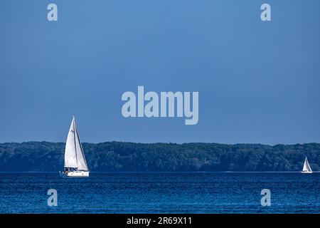 07. Juni 2023, Schleswig-Holstein, Glücksburg: Segelboote fahren auf dem Flensburg Fjord vor der Halbinsel Holnis. Die Halbinsel gehört zur Stadt Glücksburg, der nördlichsten Stadt Deutschlands (Liste auf Sylt hat den Status einer Gemeinde). Foto: Frank Hammerschmidt/dpa Stockfoto