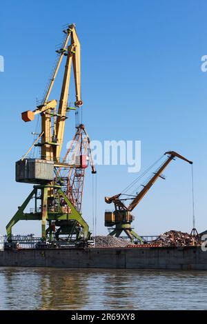 Portalkrane stehen im Hafenbereich, vertikales Industriebild Stockfoto