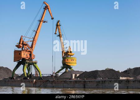 Gelb-grüne Portalkrane stehen im Kohlehafen Varna, Bulgarien Stockfoto