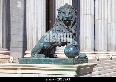 Einer der Bronzelöwen, die den Eingang des Palacio de las Cortes flankieren (Gebäude, in dem sich der spanische Abgeordnetenkongress trifft). die Statue war cr Stockfoto