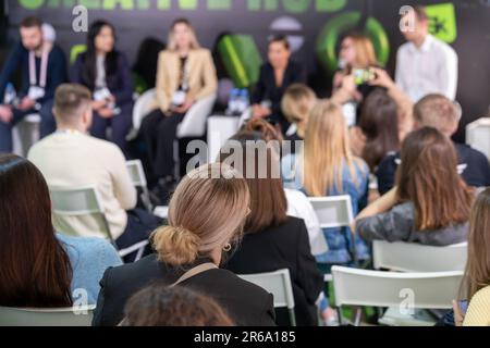 Personen, die mit führenden Rednern an einer Geschäftskonferenz teilnehmen Stockfoto
