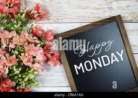 Happy Monday Text an der Tafel mit Blumenstrauß Dekoration Stockfoto