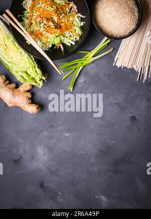 Zutaten für die Zubereitung des chinesischen Abendessens: Weizennudeln, Reis, napakohl, Ingwer, grüne Zwiebeln. Asiatische Kochzutaten. Draufsicht. Vorbereitung gesund Stockfoto