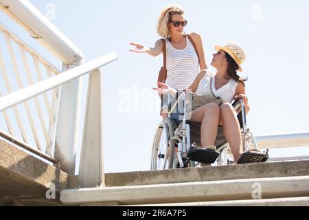Eine Frau im Rollstuhl, ganz oben auf der Treppe Stockfoto