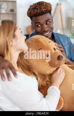Liebevoller Freund gibt Teddybär an aufgeregte Freundin Stockfoto
