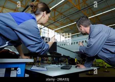 Ingenieure in der Diskussion im gewerblichen Flugzeughangar Stockfoto
