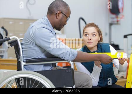 Ein behinderter Mann in einem Baumarkt mit einer Verkäuferin Stockfoto