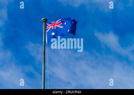Die australische Flagge bietet einen isolierten Blick mit Kopierraum und blauem Hintergrund, Victoria, Australien. Stockfoto