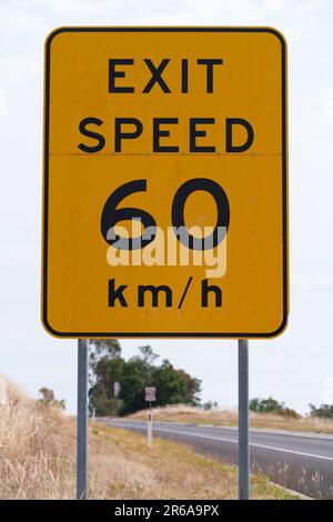 Australisches Autobahnausfahrtsschild mit einer Geschwindigkeit von 60 km/h mit schwarzer Schrift und gelb lackiertem Metallhintergrund, Victoria, Australien. Stockfoto