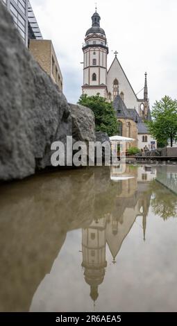 Leipzig, Deutschland. 08. Juni 2023. Das St. Die Thomas-Kirche in Leipzig spiegelt sich im Wasser eines Brunnens wider. Am Abend wird das Bach-Festival Leipzig in der Thomaskirche eröffnet. Das Bach Festival Leipzig erinnert an Johann Sebastian Bachs Amtseinführung als Thomaskantor vor genau 300 Jahren. Bis Juni 18 sind rund 160 Veranstaltungen im Programm, die dieses Jahr das Motto „Bach für die Zukunft“ tragen. Kredit: Hendrik Schmidt/dpa/Alamy Live News Stockfoto