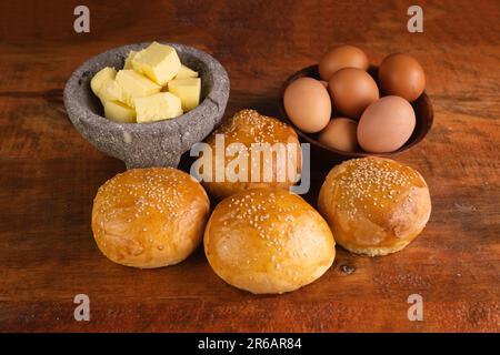 Eine Nahaufnahme frisch gebackener Brötchen mit Butter und Eiern auf dem Tisch Stockfoto