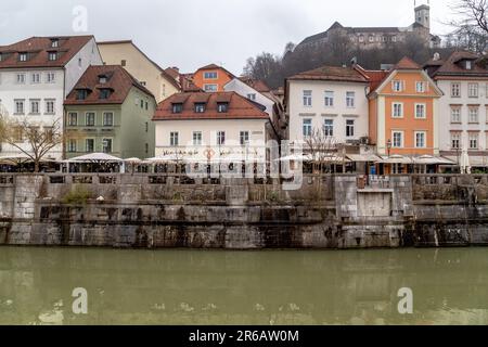 LJUBLJANA, SLOWENIEN - 7. MÄRZ 2023: Dies ist ein Blick auf die historischen Häuser am Ufer des Flusses Ljubljanica. Stockfoto