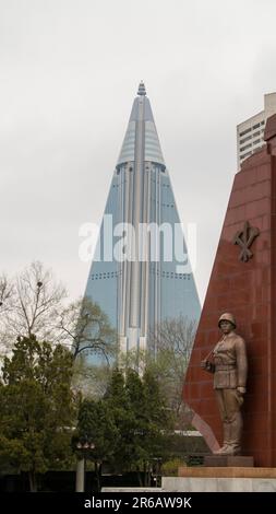 Pjöngjang, Nordkorea (Demokratische Volksrepublik Korea). April 2018. Victorious war Museum mit Ryugyong Hotel im Hintergrund. Stockfoto